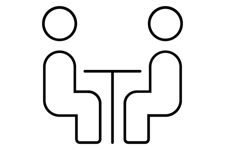 Zwei Personen sitzen sich an einem Tisch gegenüber.